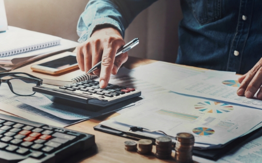 businessman-using-calculator-with-hand-holding-pen-working-office